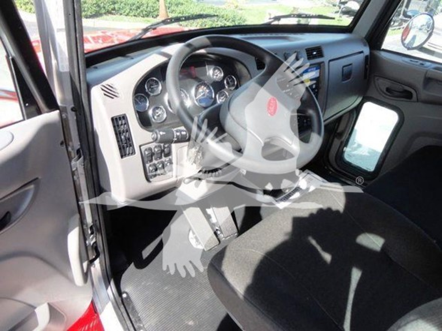 Peterbilt truck cab interior showing steering wheel, dashboard, and driver's seat with instruments and controls visible.