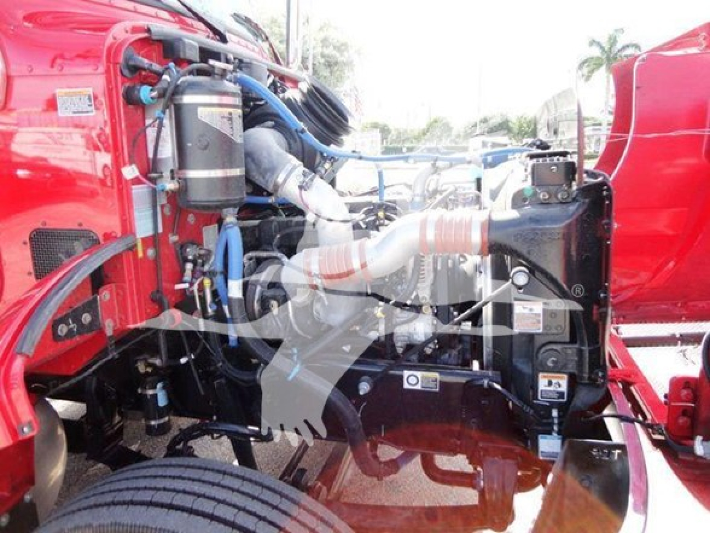 Peterbilt 337 engine bay view showing various components and hoses in red truck, starting near left side with air filter canister and intake pipes.