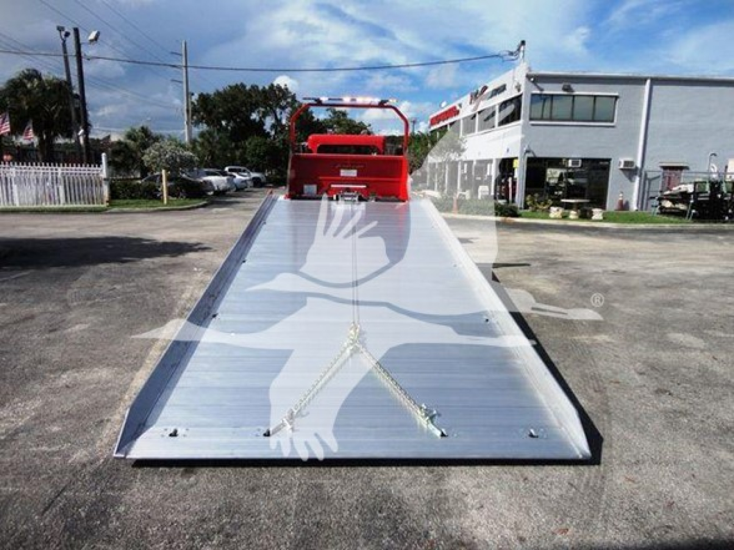Peterbilt 337 rollback bed with winch and reflective metal surface, low-angle view apron leading to cab area in lot