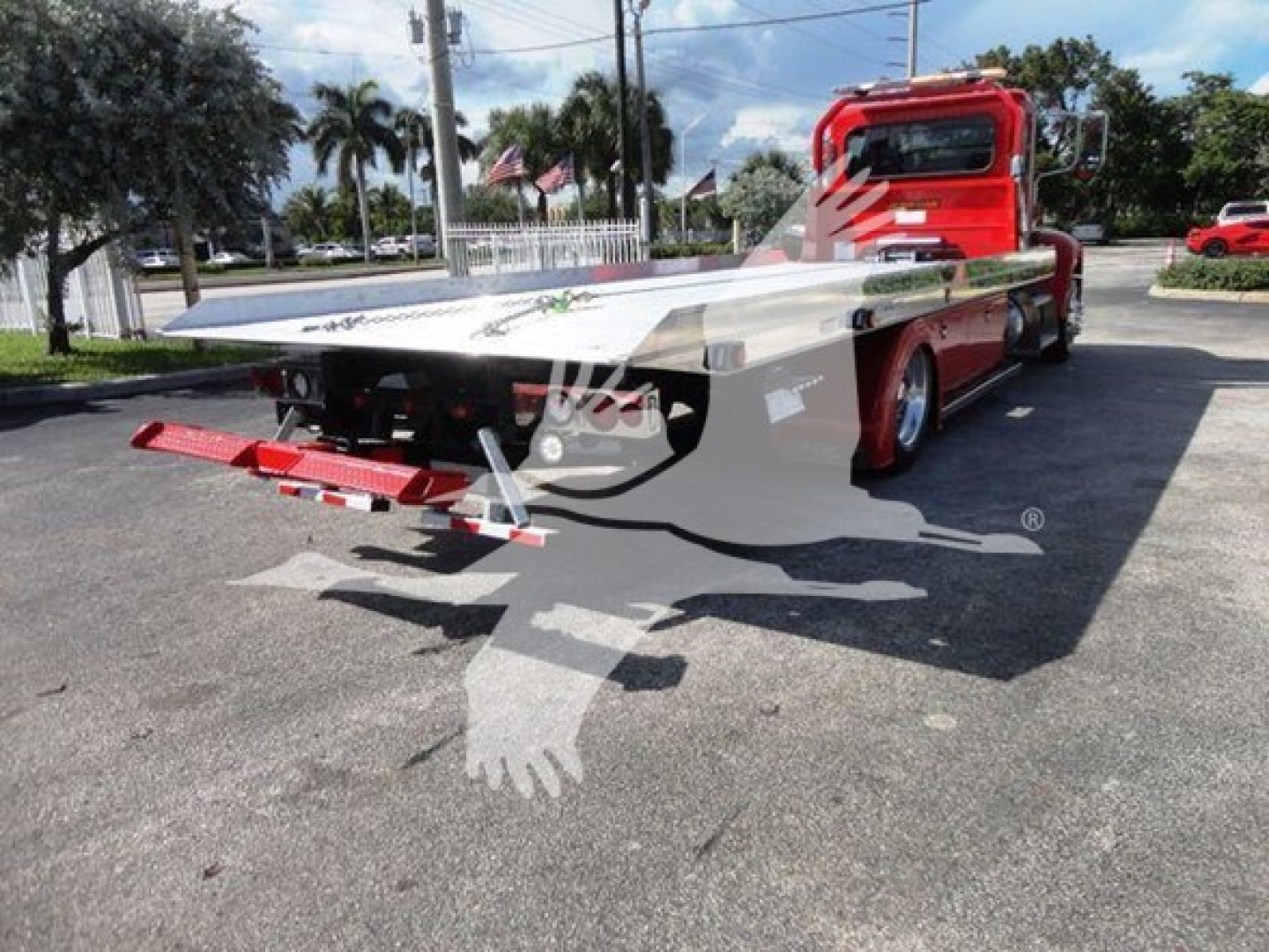 Peterbilt 337 rollback truck showing flatbed and rear view with wheel chocks and ramp.