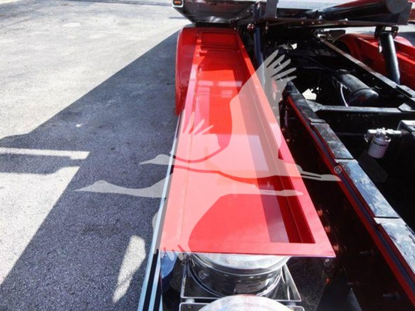 Peterbilt 337 rollback truck image showing red fender/side panel and chassis frame with hydraulic components and storage area.