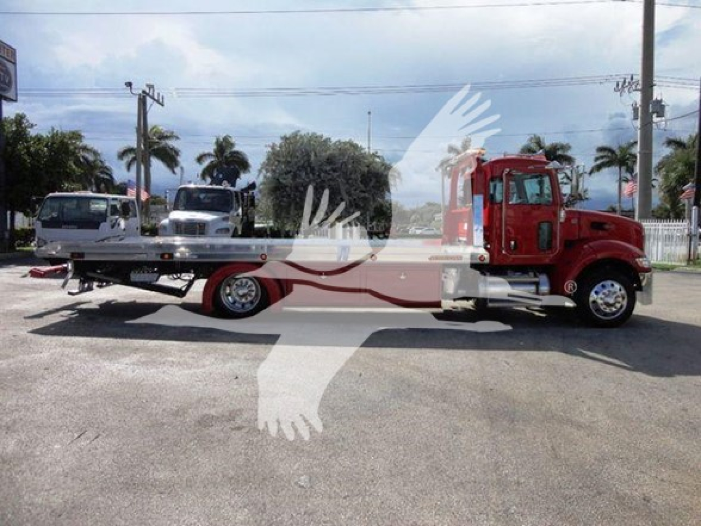 Peterbilt 337 rollback truck with flatbed and red cab, side view.