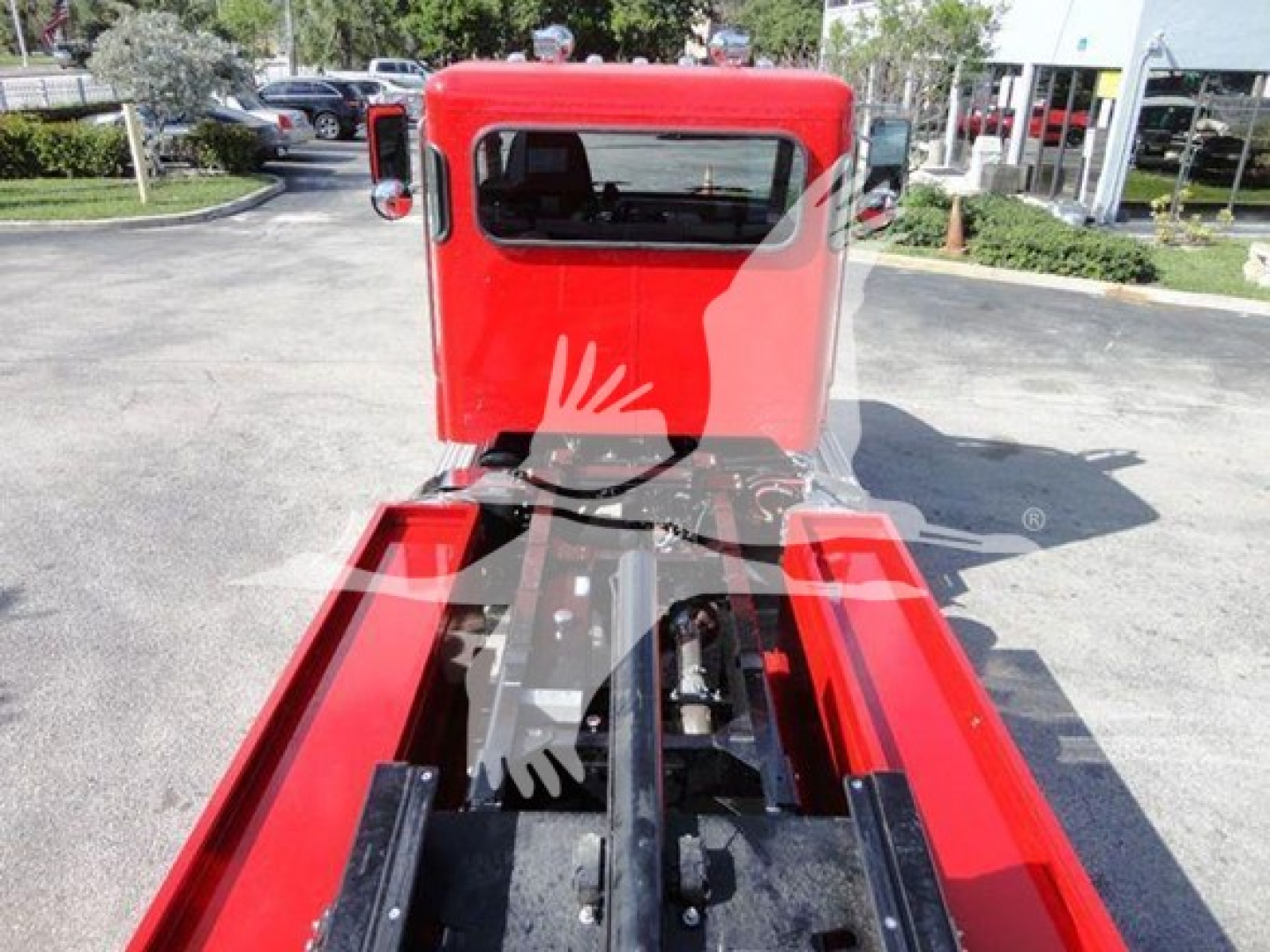 Peterbilt 337 rollback truck cab and chassis viewed from rear with red cab, extending frame rails, and hydraulics in center.