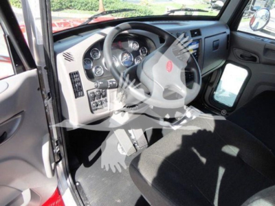 Peterbilt truck cab interior showing steering wheel, dashboard, and driver's seat with instruments and controls visible.