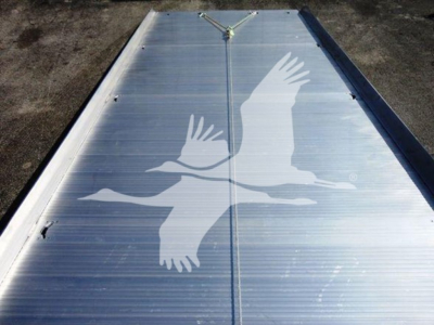 Flatbed truck bed with silver aluminum surface and a large white bird decal in flight.