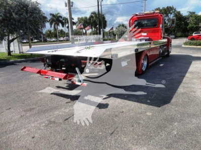 Peterbilt 337 rollback truck showing flatbed and rear view with wheel chocks and ramp.
