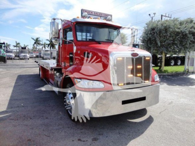Peterbilt 337 rollback truck in red with chrome bumper and large white grille, side view showing front cab and flatbed platform.