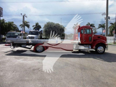 Peterbilt 337 rollback truck with flatbed and red cab, side view.