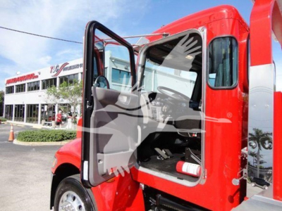 Peterbilt 337 rollback truck with open driver door, red cab, interior dash and seat visible.
