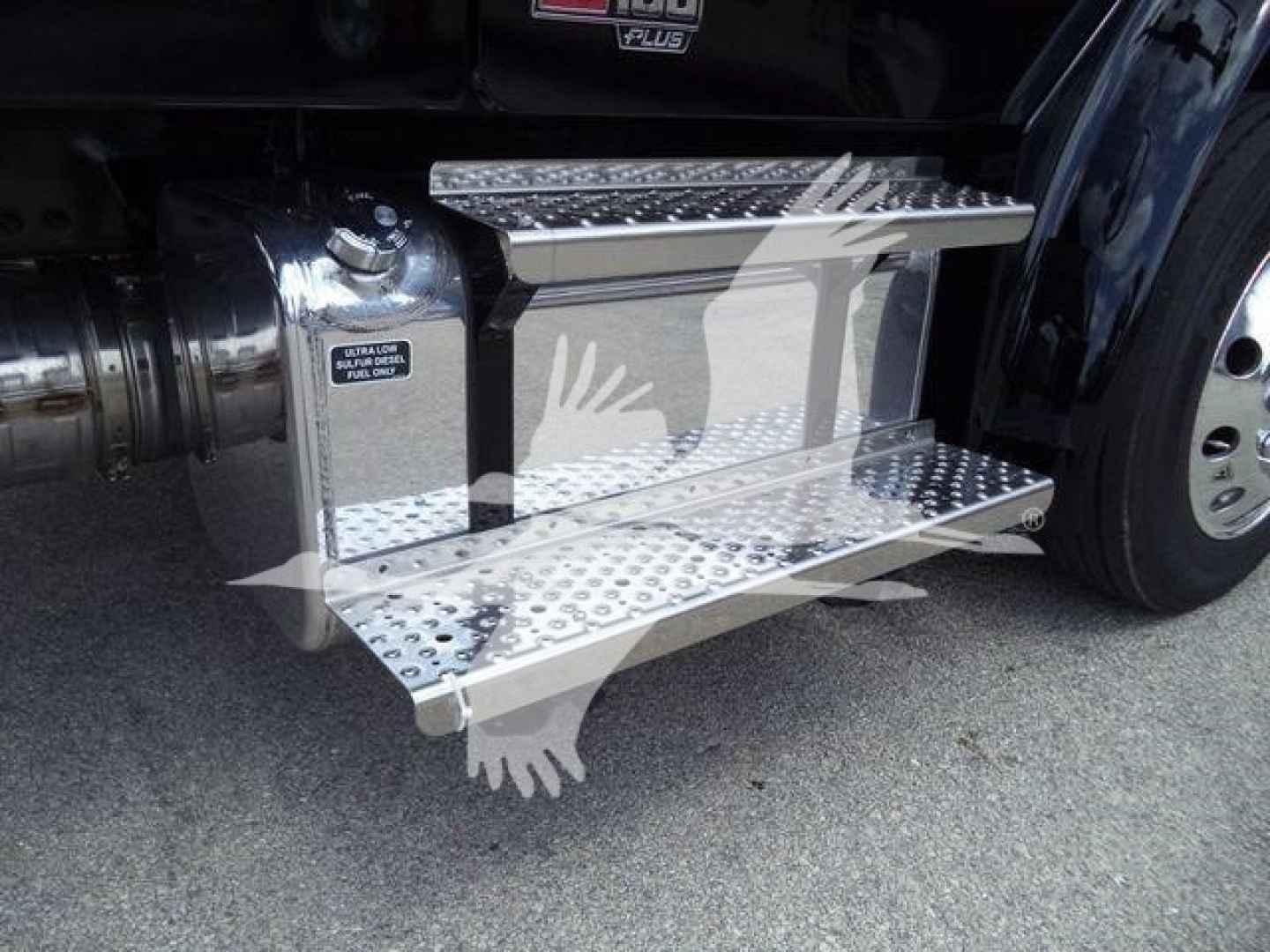 Freightliner M2 106 truck side view showing polished aluminum retractable drop steps with textured treads and a portion of the fuel/air intakes; visible wheel and chrome accents.