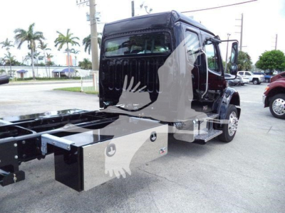 Truck cab and chassis of a 2027 Freightliner M2 106 rollback with flatbed mount and step access, side view showing black cab, dual rear wheels, and chassis extensions.