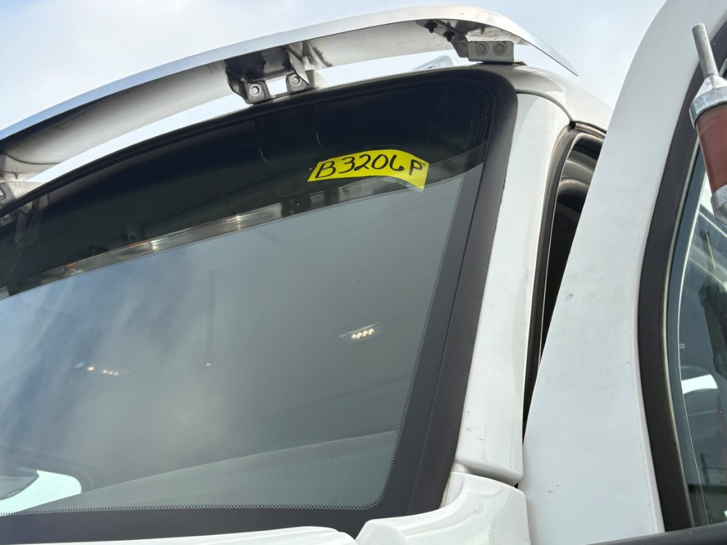 Kenworth T880 front cabin window with yellow B320L P sticker visible