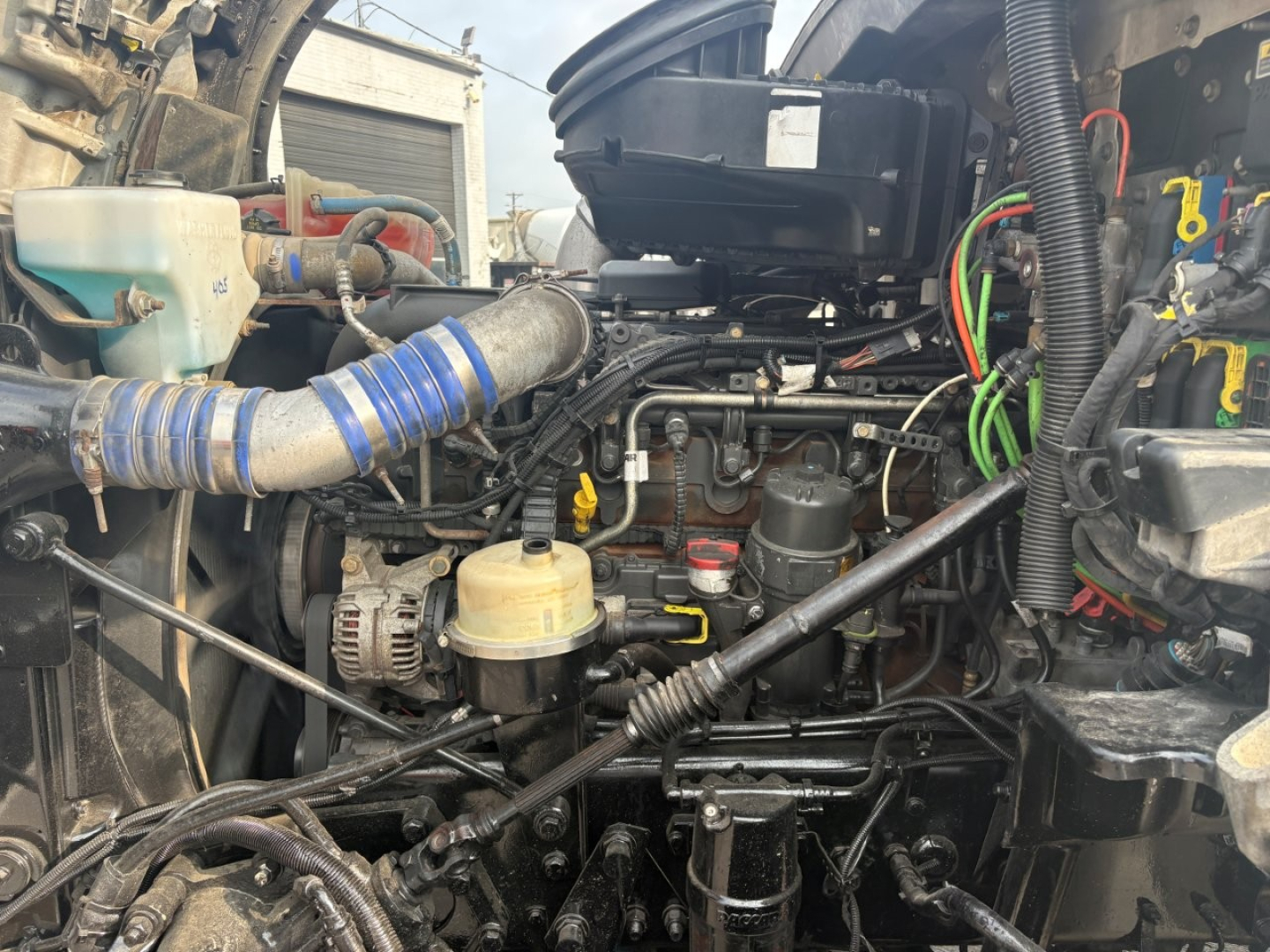 Kenworth T880 engine bay showing label text on reservoir and surrounding hoses and wiring