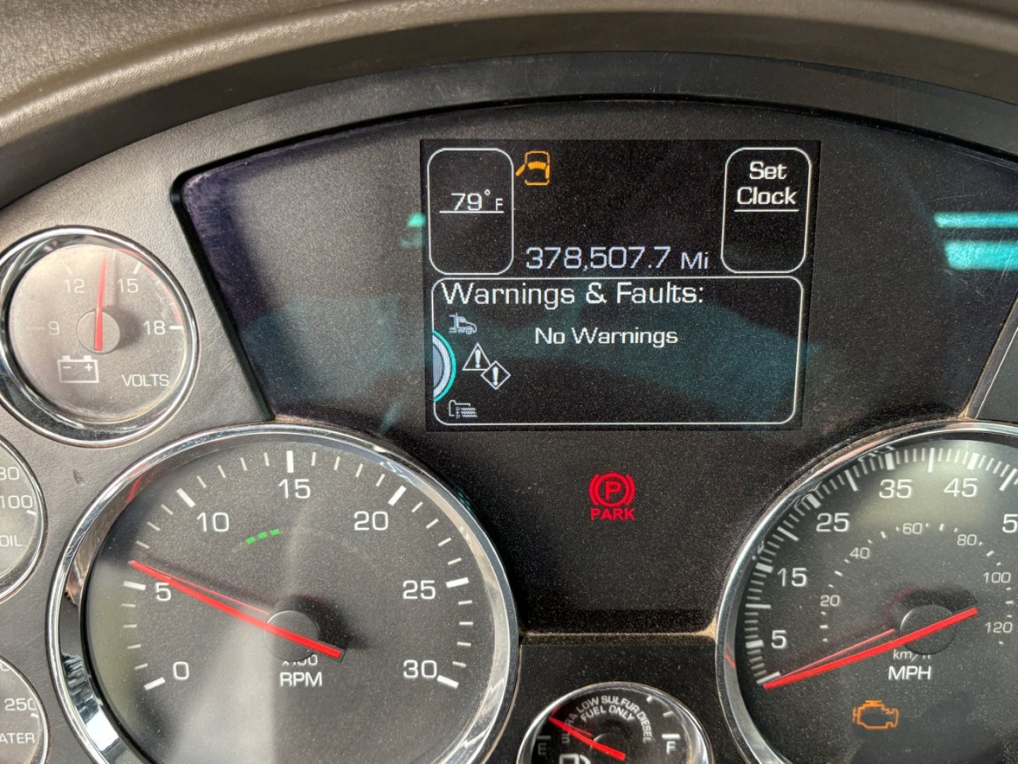 Kenworth T880 instrument cluster showing digital display with 378,507.7 mi, No Warnings, and warning icons in the center console.