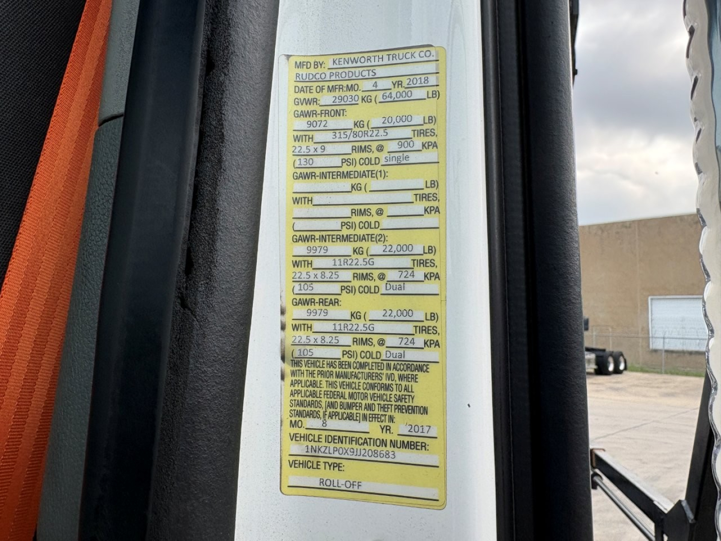 Vehicle VIN plate on Kenworth T880 showing GVWR and axle ratings, door jamb sticker with load specs and vehicle identifiers.