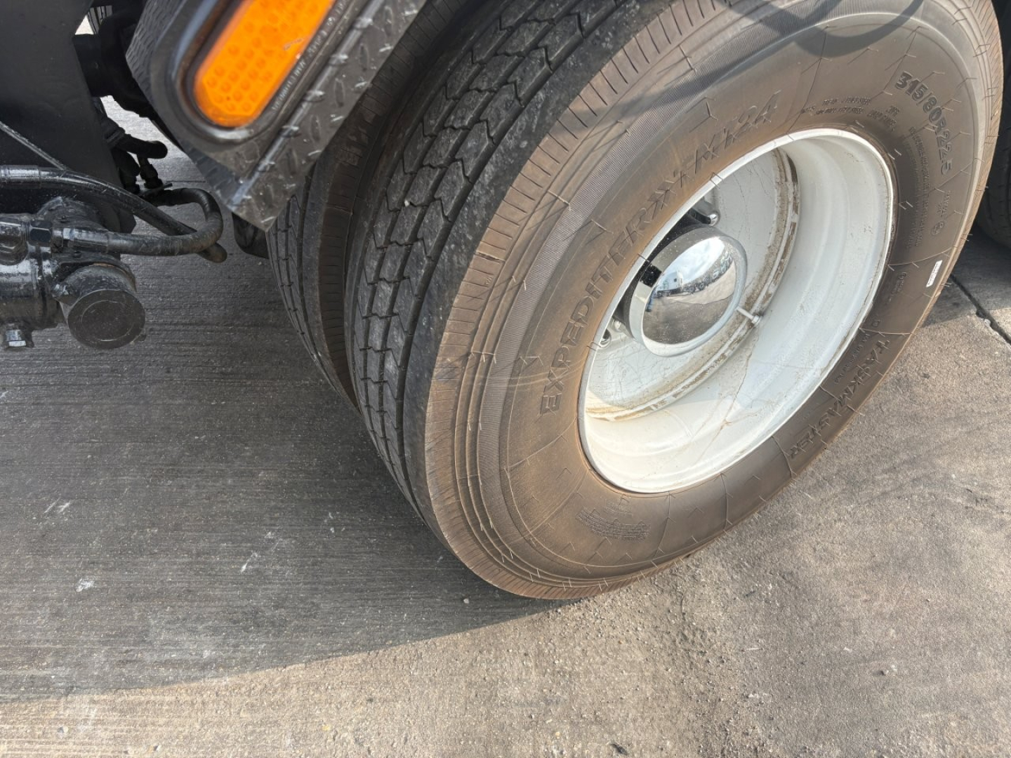 Kenworth T880 wheel and front tire close-up showing Goodyear tire with white wheel and fender area.