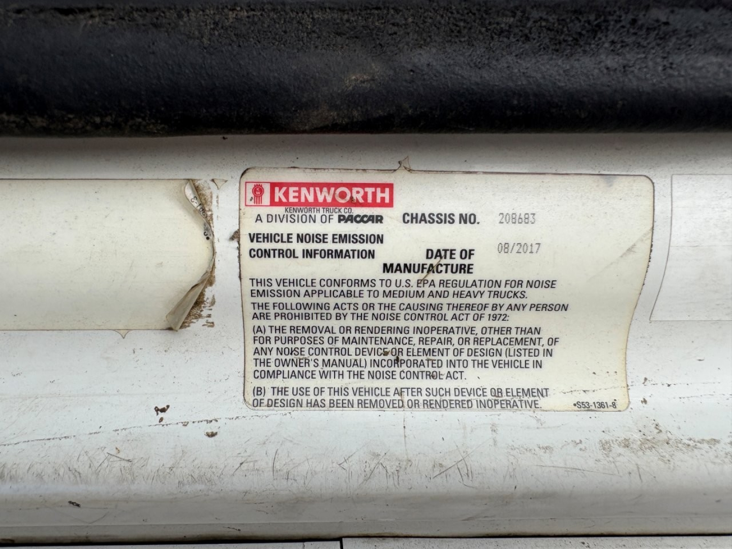 Kenworth vehicle label showing VIN and Noise Emission Control Information sticker on a truck door jamb.