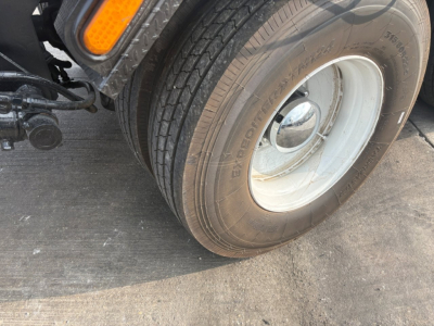 Kenworth T880 wheel and front tire close-up showing Goodyear tire with white wheel and fender area.