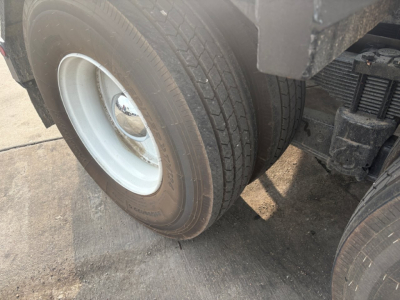 Kenworth T880 wheel and dual rear tire view showing front wheel and suspension components.