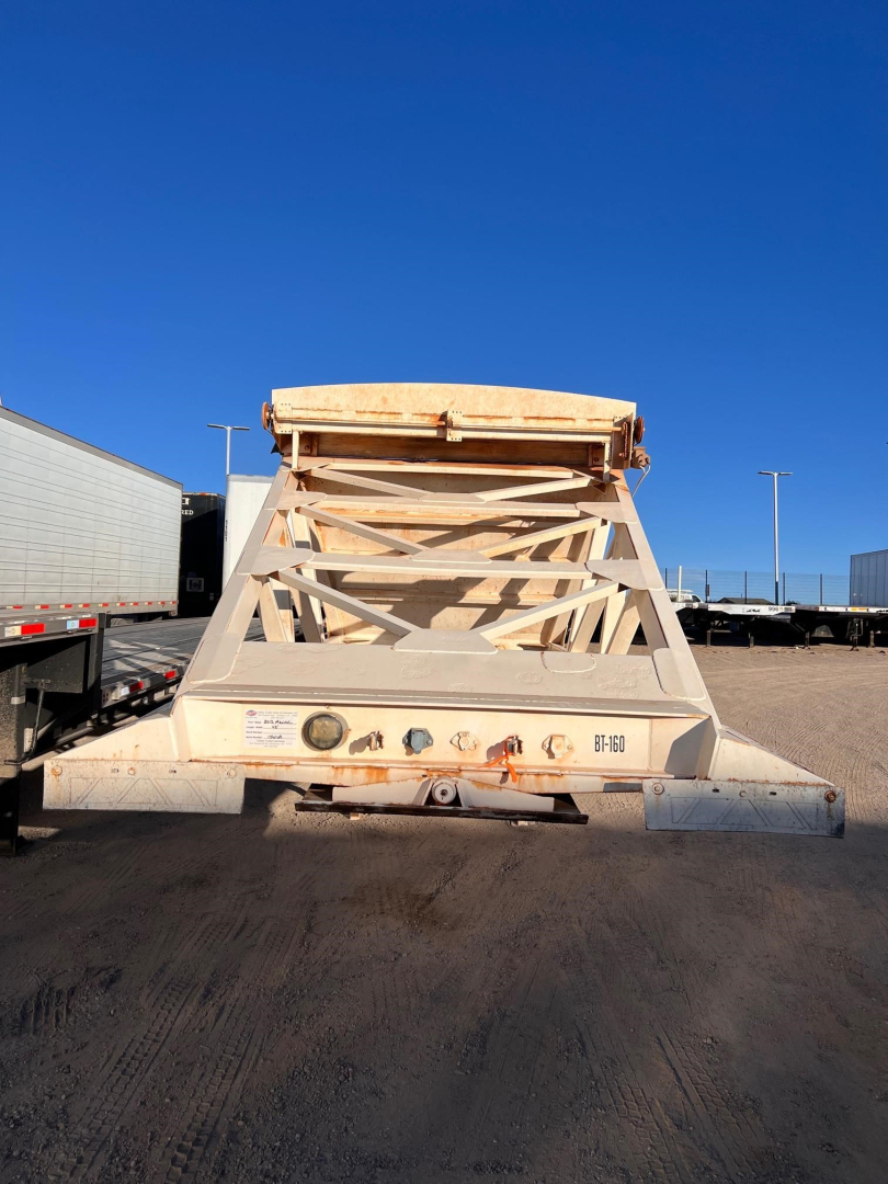 Manac light weight bottom dump trailer viewed from rear showing frame lattice and tailgate.