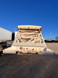 Manac light weight bottom dump trailer rear view showing hydraulic ram and axle frame.