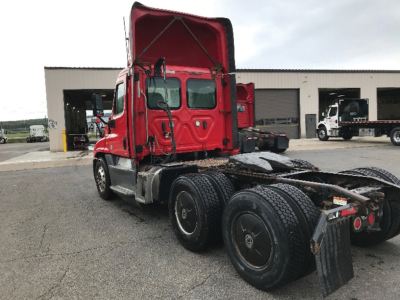 Freightliner Cascadia125 truck cab and chassis in red, rear view with open hood and dual rear axles.