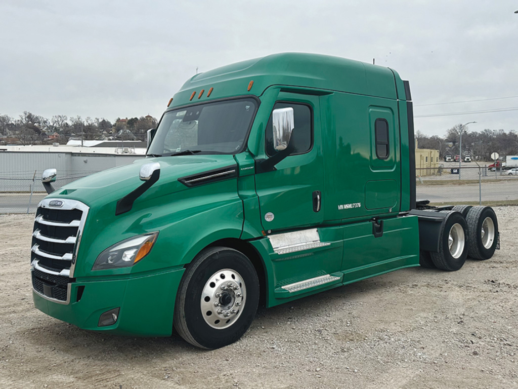 Green Freightliner Cascadia 126 tractor cab with sleeper, side view showing front grille, windows, and dual rear axles.