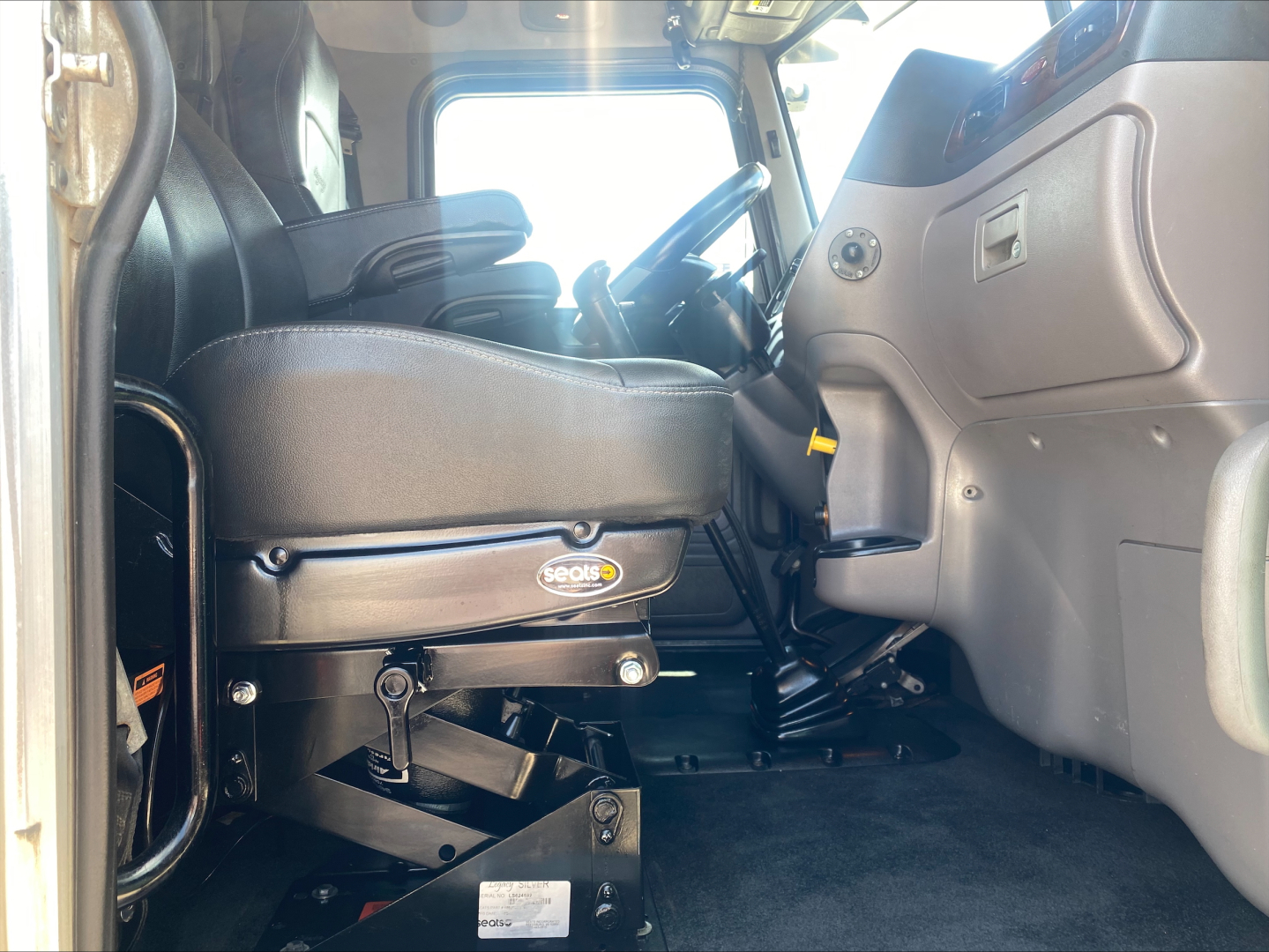Interior cab view of 2019 Peterbilt 389 sleeper truck showing driver's seat, dashboard, and steering wheel from doorway.