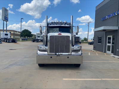 Peterbilt 389 conventional sleeper truck front view showing large chrome grille, bumper, and multiple cab roof lights.