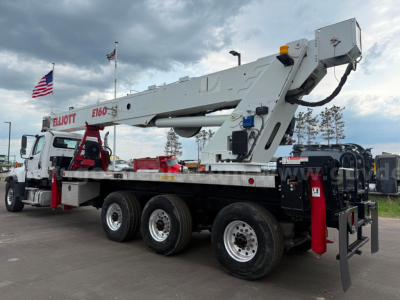 Freightliner 114SD boom truck shown in side profile with extendable boom folded overhead and multiple axles.