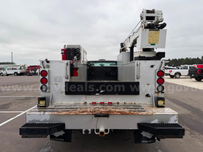 Rear view of a 2011 Ford F550 service/utility truck with flatbed and equipment racks, showing dual rear lights, bumper steps, and a crane/boom on the bed.