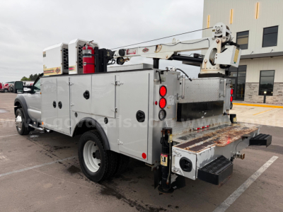 Service/utility bucket truck body on a Ford F550 with utility compartments, crane arm, dual rear doors, and rear stabilizers.