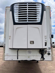 Refrigerated trailer rear with large cooling unit and vents, white body, with black trim and side access doors.