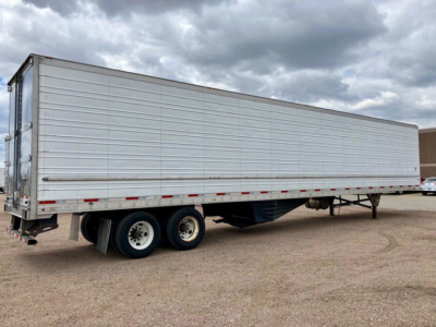 Trailer side view showing a used 2022 Utility refrigerated trailer with tandem axles and aluminum siding.