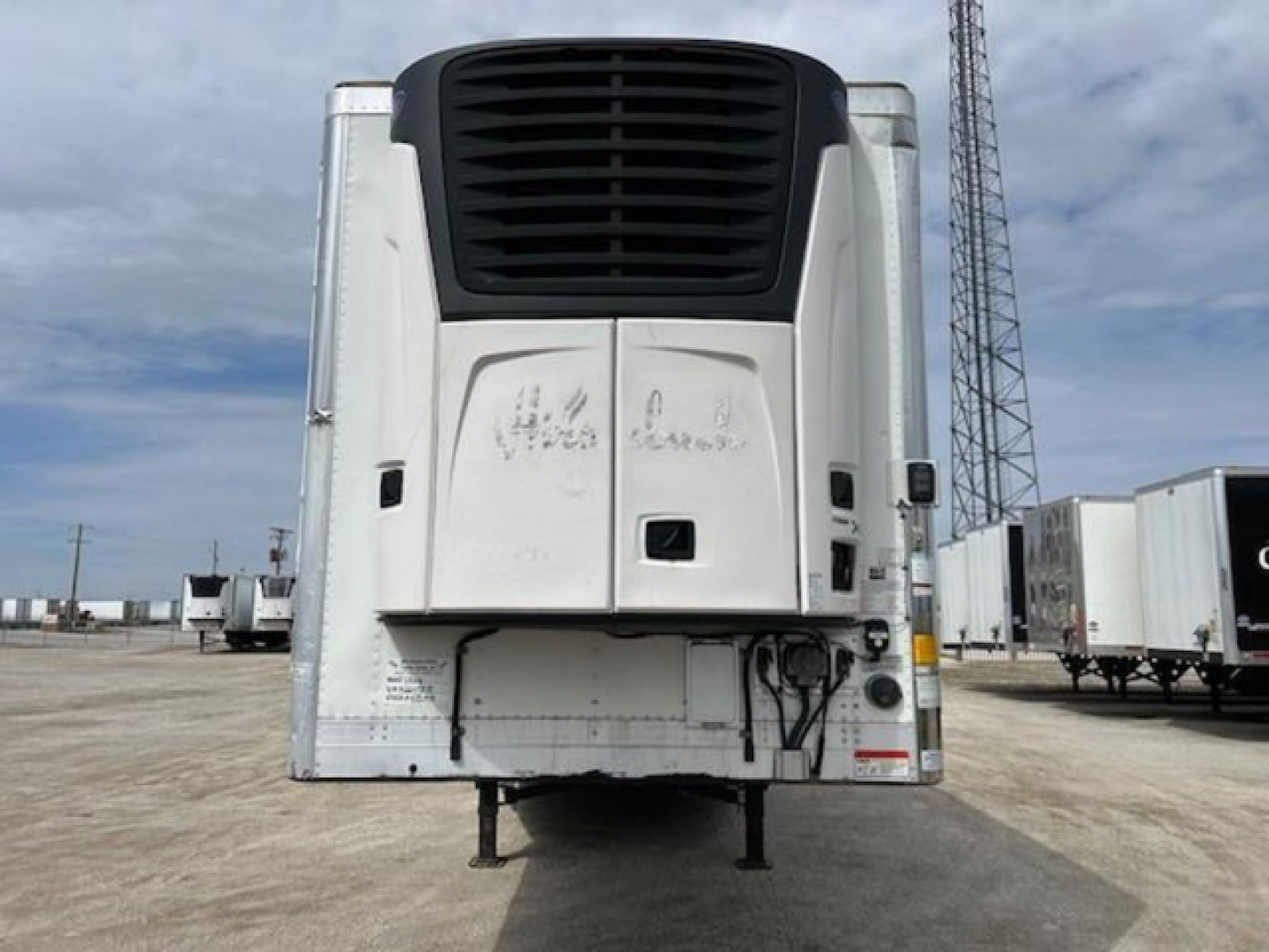 Rear view of a 2019 Utility refrigerated trailer with black top vent and white body, stock number KTS1919, VIN visible on door area.