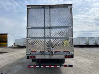 Rear view of a 2019 Utility refrigerated trailer with diamond plate aluminum doors, safety decals, and red/white rear underride guard.
