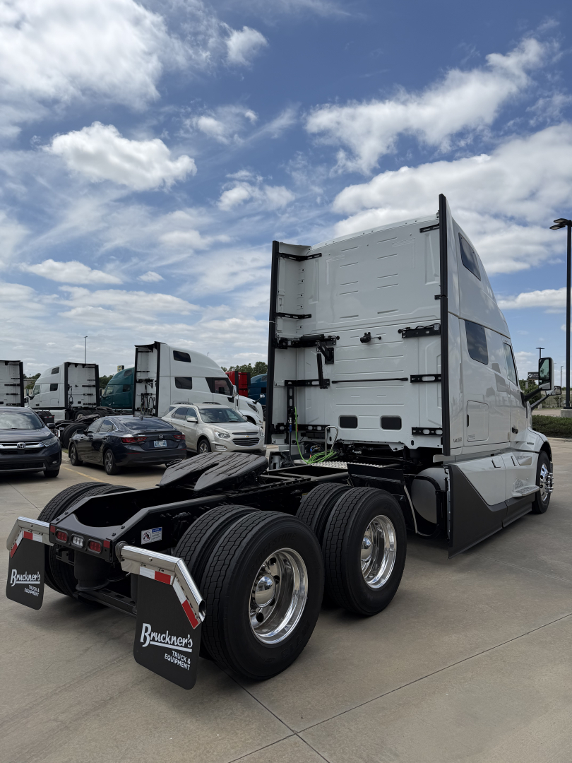 Volvo VNL64T860 tractor cab rear view showing fifth wheel area and rear dual axle with tires in a dealership lot.