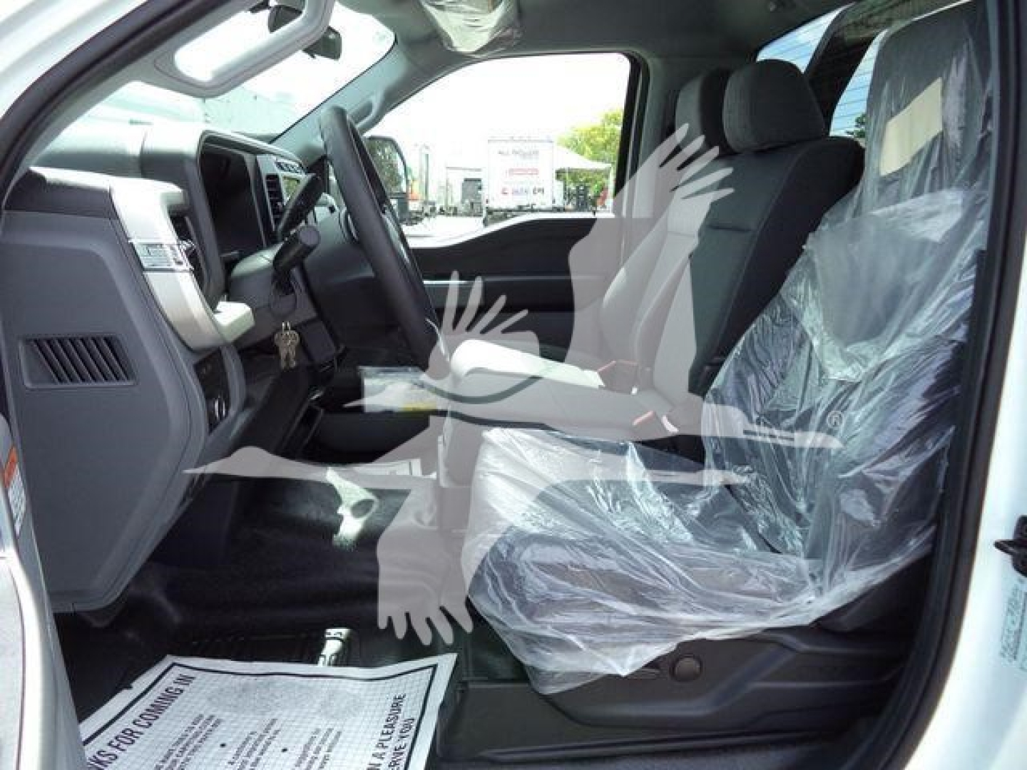 Ford F-550 cab interior with front seats covered in protective plastic and dashboard visible.
