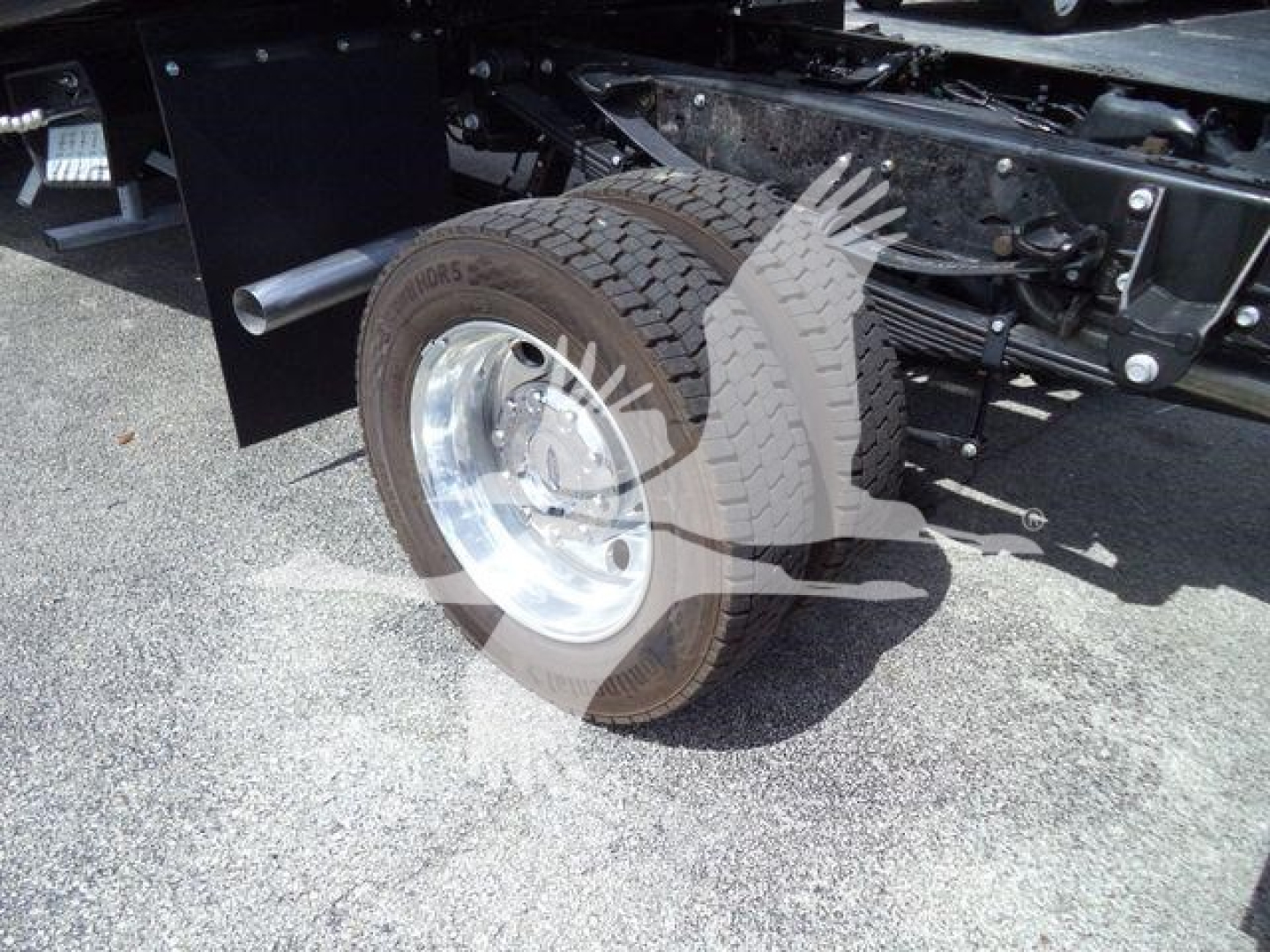 Truck rear wheel and suspension showing tire, wheel, and part of frame on a new Ford F550 rollback truck.