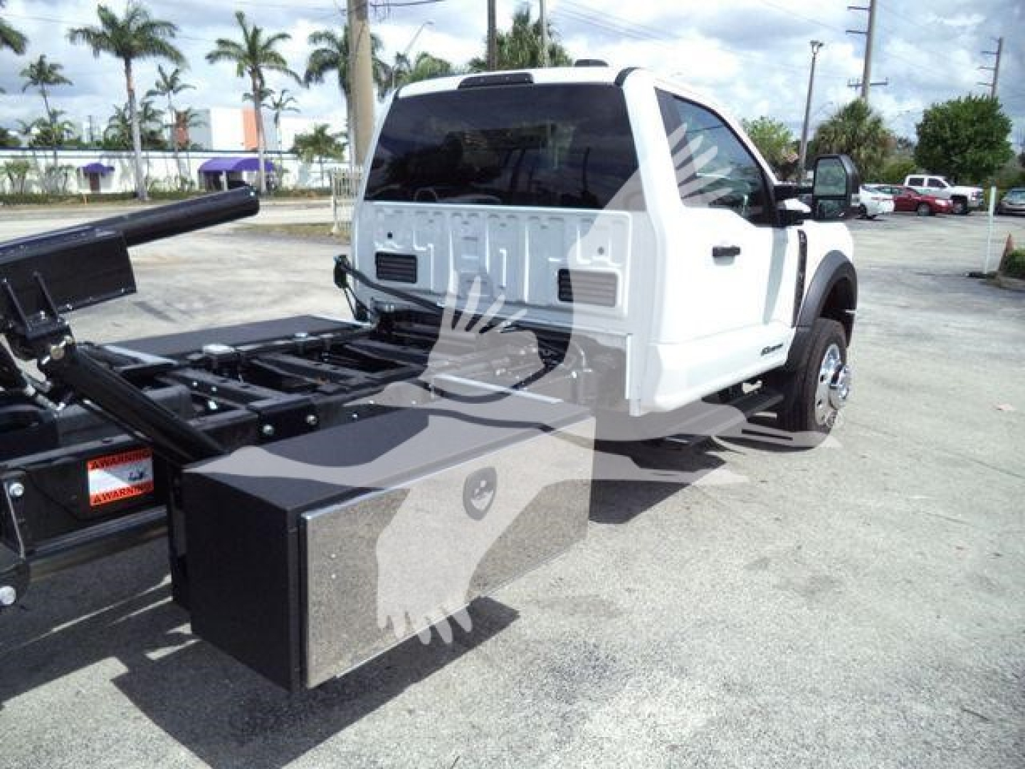 Ford F550 rollback truck side view showing rear flatbed and tool storage box attached