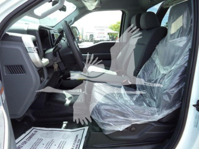Ford F-550 cab interior with front seats covered in protective plastic and dashboard visible.