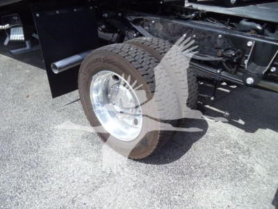 Truck rear wheel and suspension showing tire, wheel, and part of frame on a new Ford F550 rollback truck.