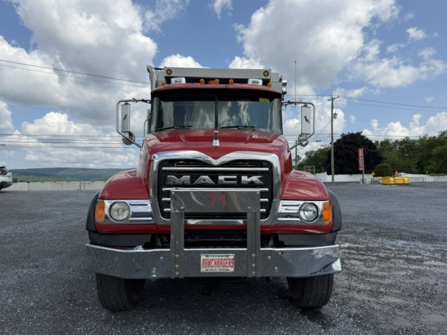 Mack CV713 dump truck front view showing grille, bumper guard, headlights, and cab with Mack emblem
