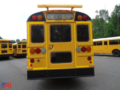Rear view of a yellow IC Corporation CE Series school bus with black bumper and rear lights; visible is the school bus emblem and tail lights.