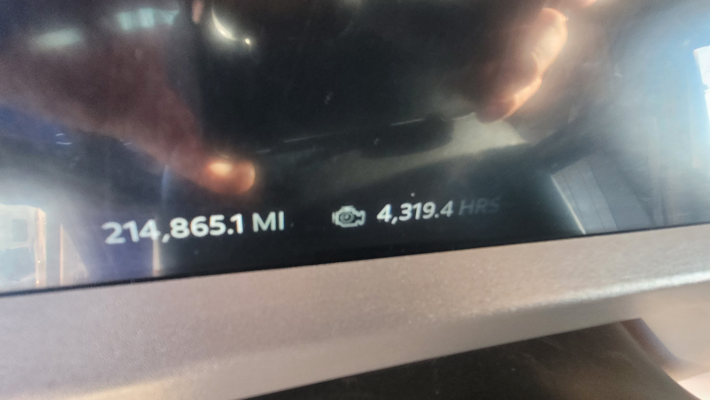 Dashboard display showing odometer reading 214,865.1 MILES and time 4,319.4 HRS on Peterbilt 579 dash.