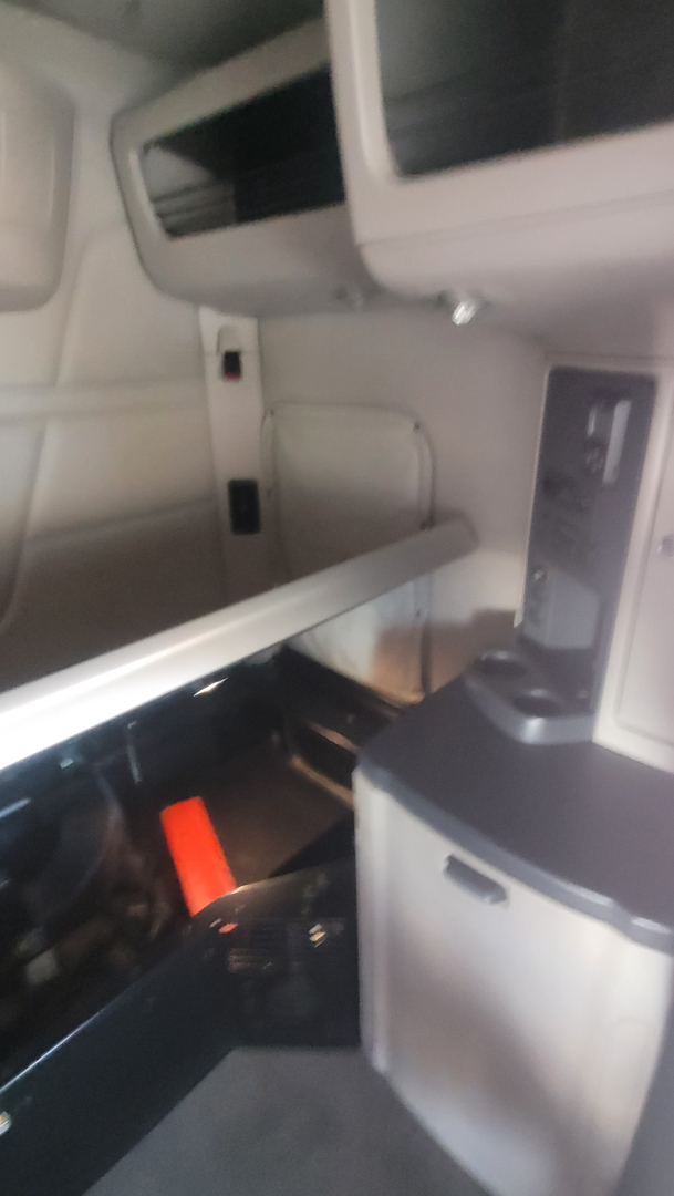 Peterbilt 579 interior cabin area showing sleeper/storage compartments and dash panel.