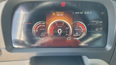 Peterbilt dashboard display showing digital gauges and warning text. Center shows large speedometer with '0' MPH. Left gauge indicates oil pressure and fuel; right gauge shows hydraulic/engine data. On top center, warning: 'Fuel Low Add Fue