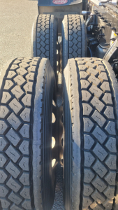 Peterbilt truck chassis showing dual rear axles with four large tires and textured tread.
