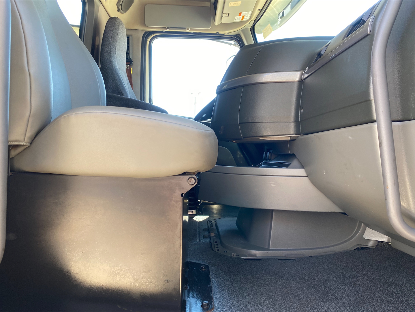Interior of a 2021 Volvo VNL300 truck cab with captain chairs and center console raised