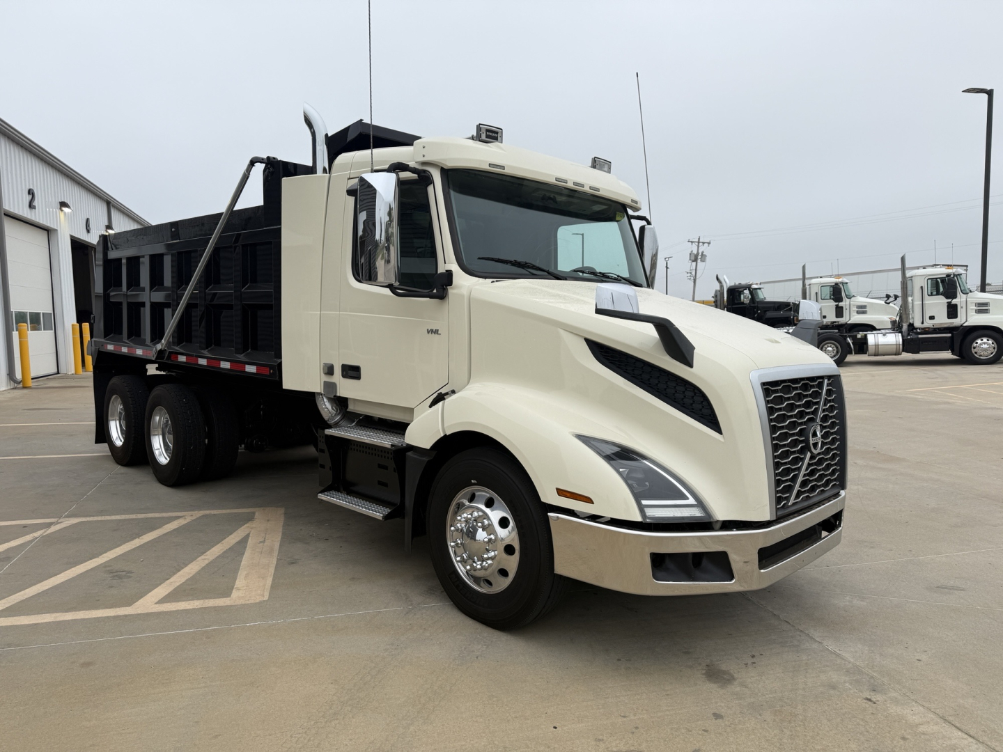 Volvo VNL300 dump truck from the front-left side showing cab, grille, and dump bed.
